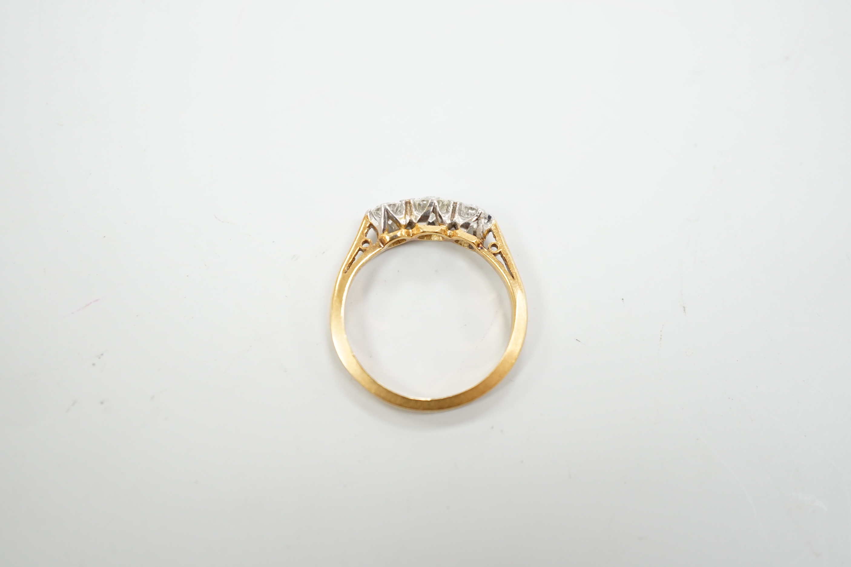 An 18ct, plat and three stone diamond set ring, size K, gross weight 2.7 grams.